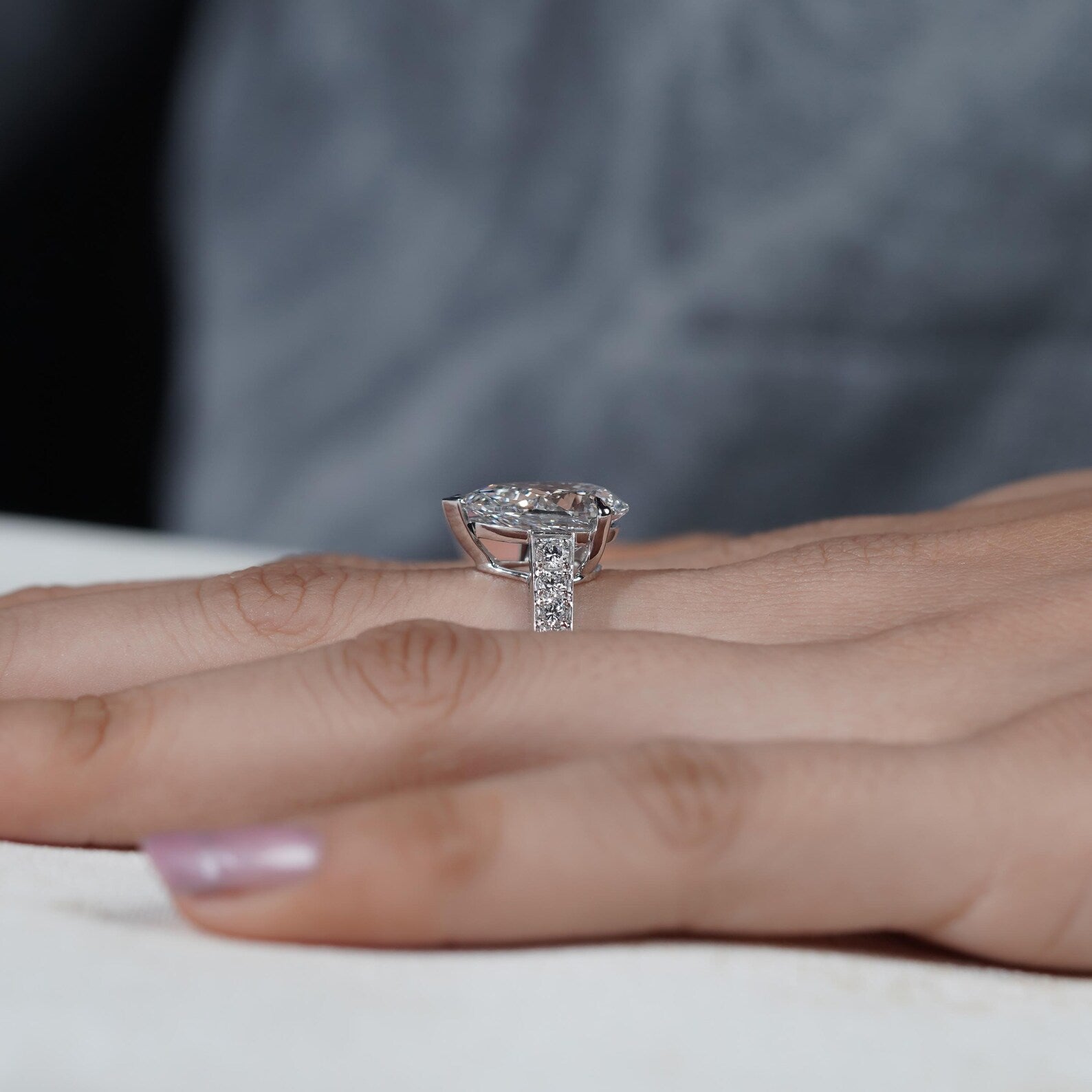 Diamond ring on a person's finger with a blurred background

