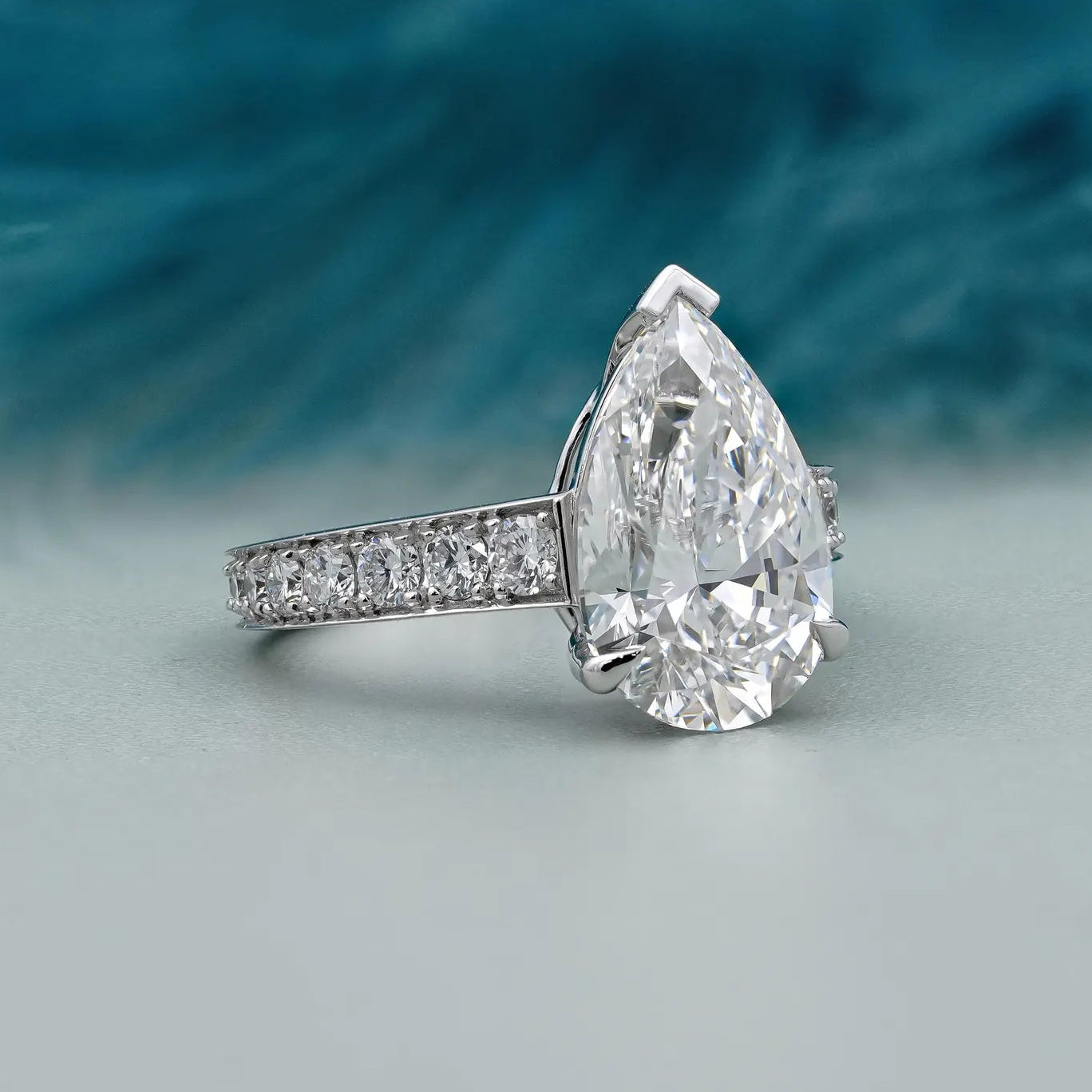 Lab grown pear cut engagement ring with pave band
