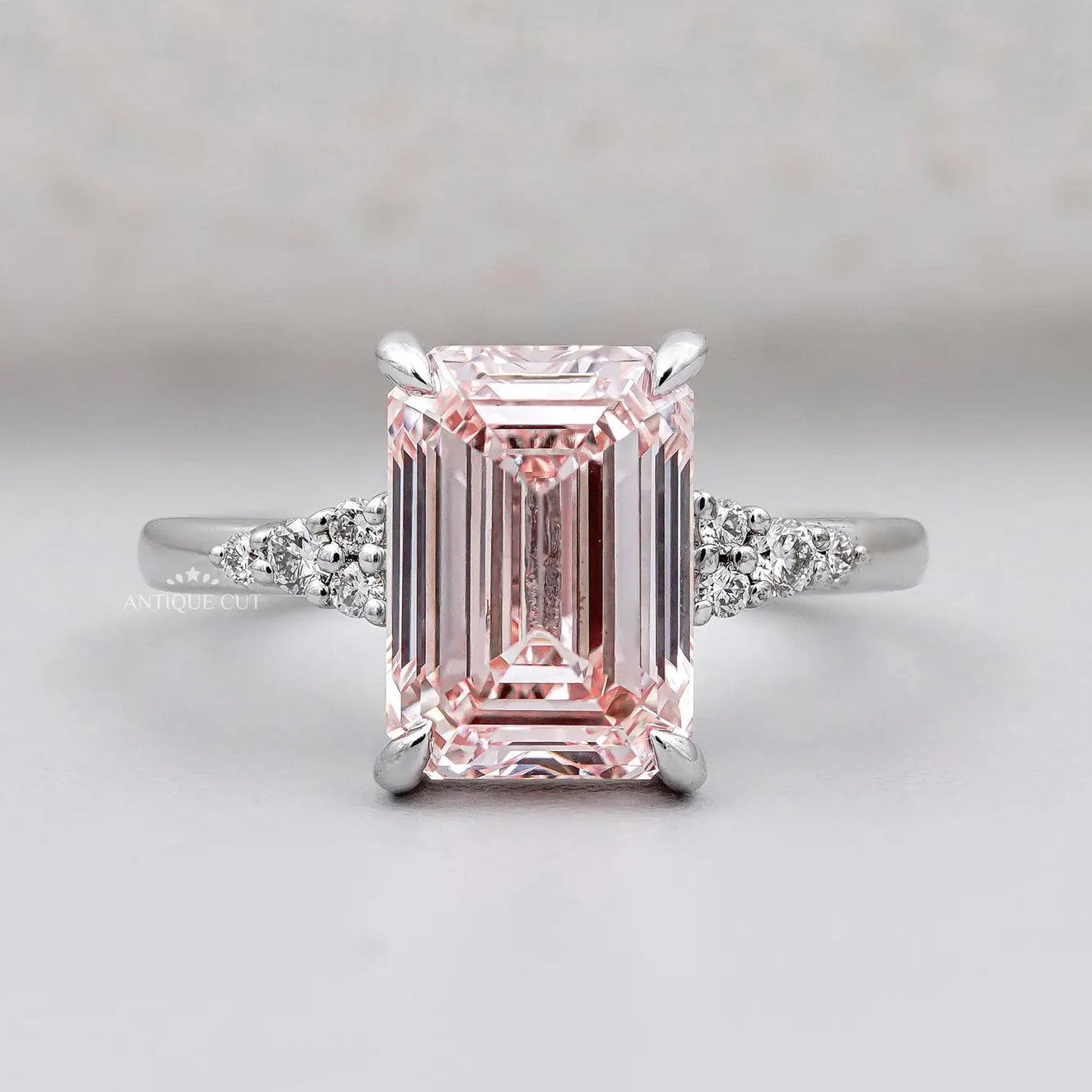 Emerald cut pink diamond solitaire ring with side diamond clusters