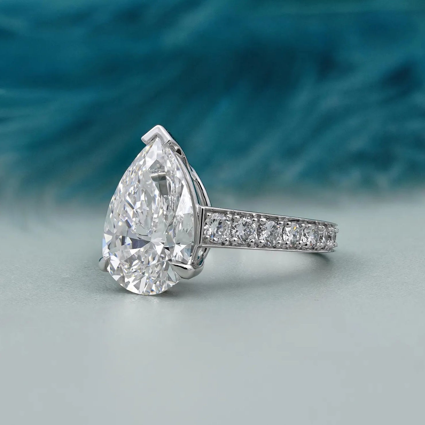 Lab grown pear cut engagement ring with pave band
