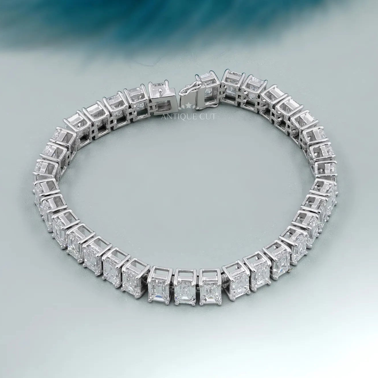 Silver bracelet with square-cut stones on a light gray background