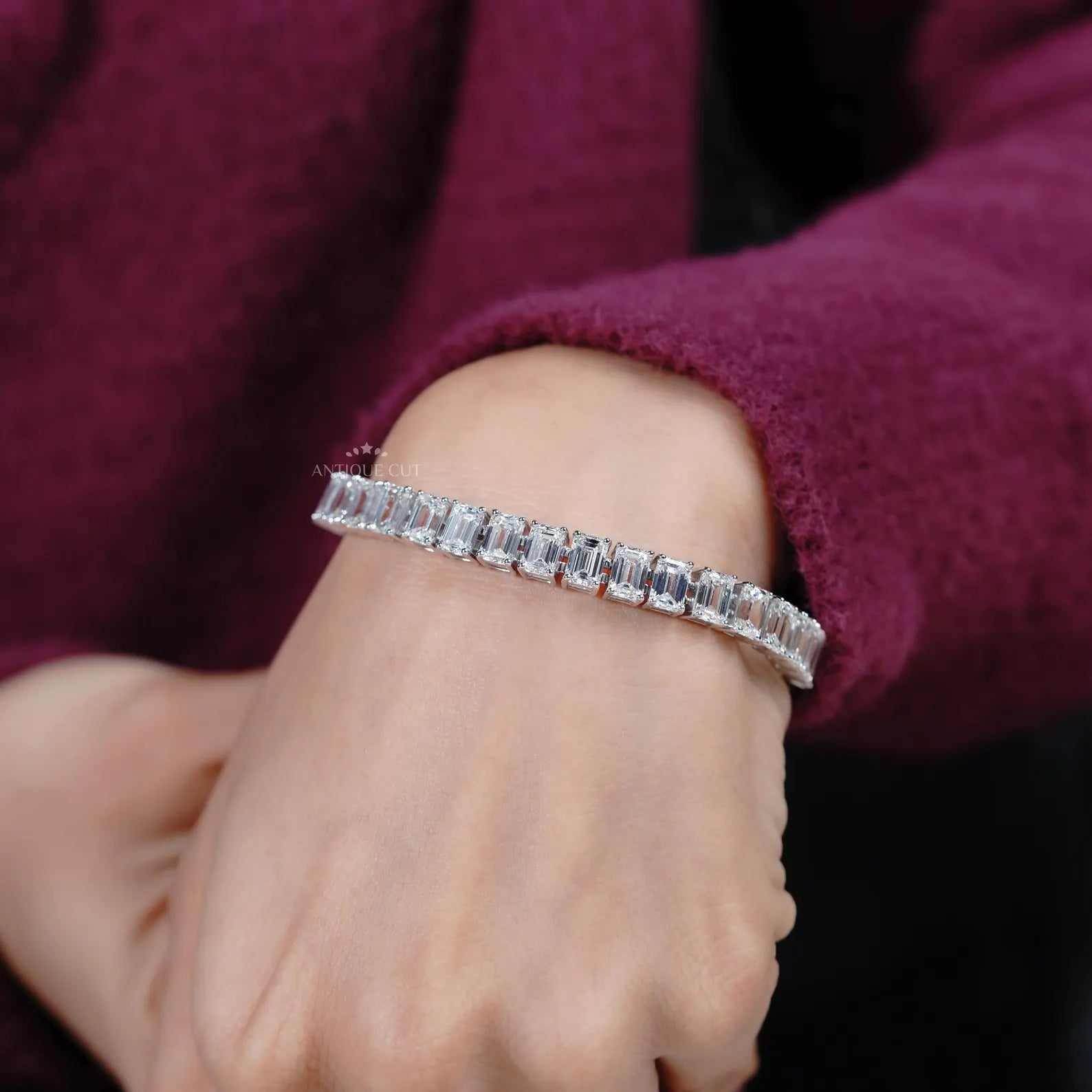 Diamond bracelet with emerald-cut diamonds on a gradient blue and gray background