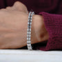 Diamond bracelet with emerald-cut diamonds on a gradient blue and gray background