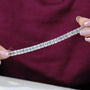 Diamond bracelet with emerald-cut diamonds on a gradient blue and gray background