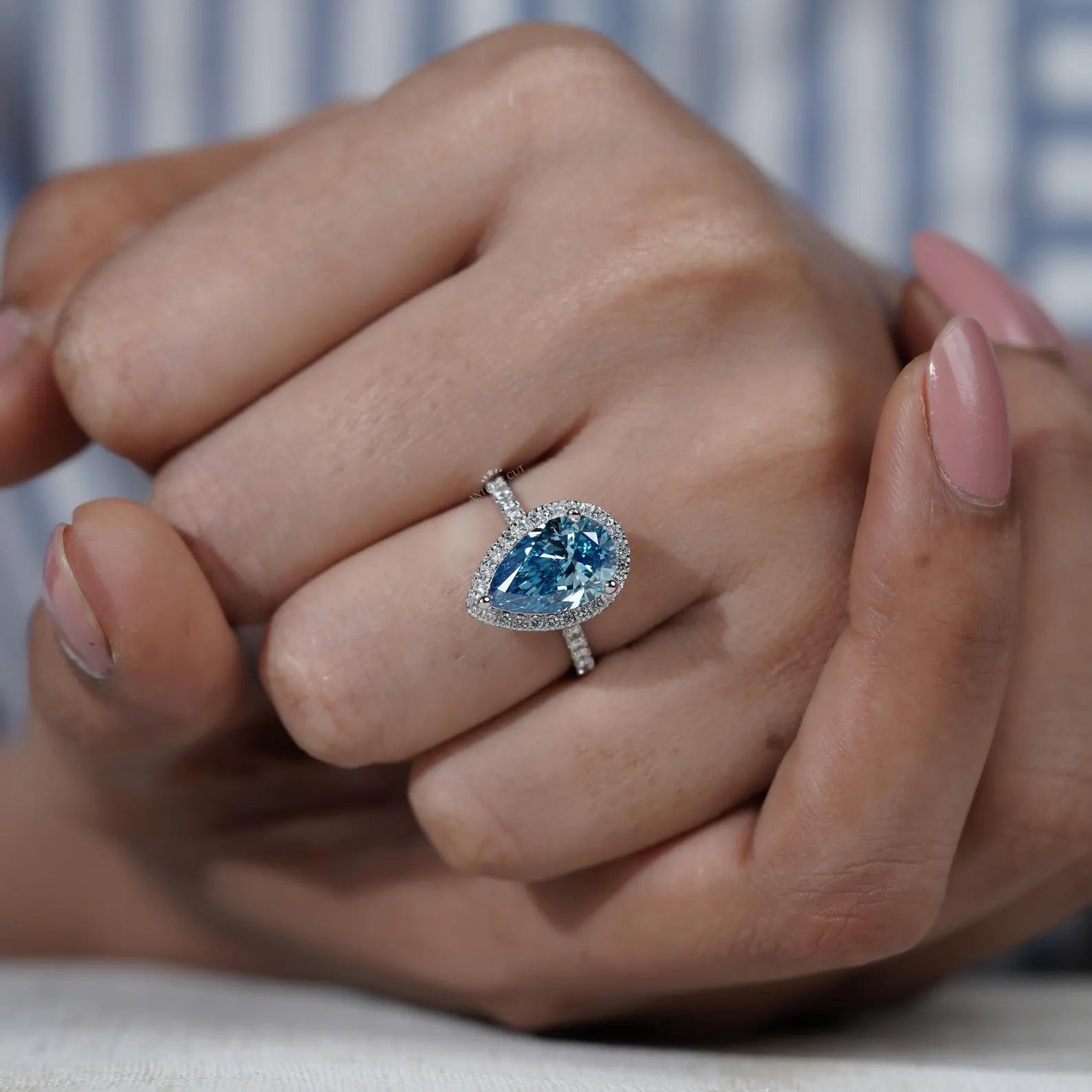 Lab grown blue diamond teardrop ring with round cut pave band