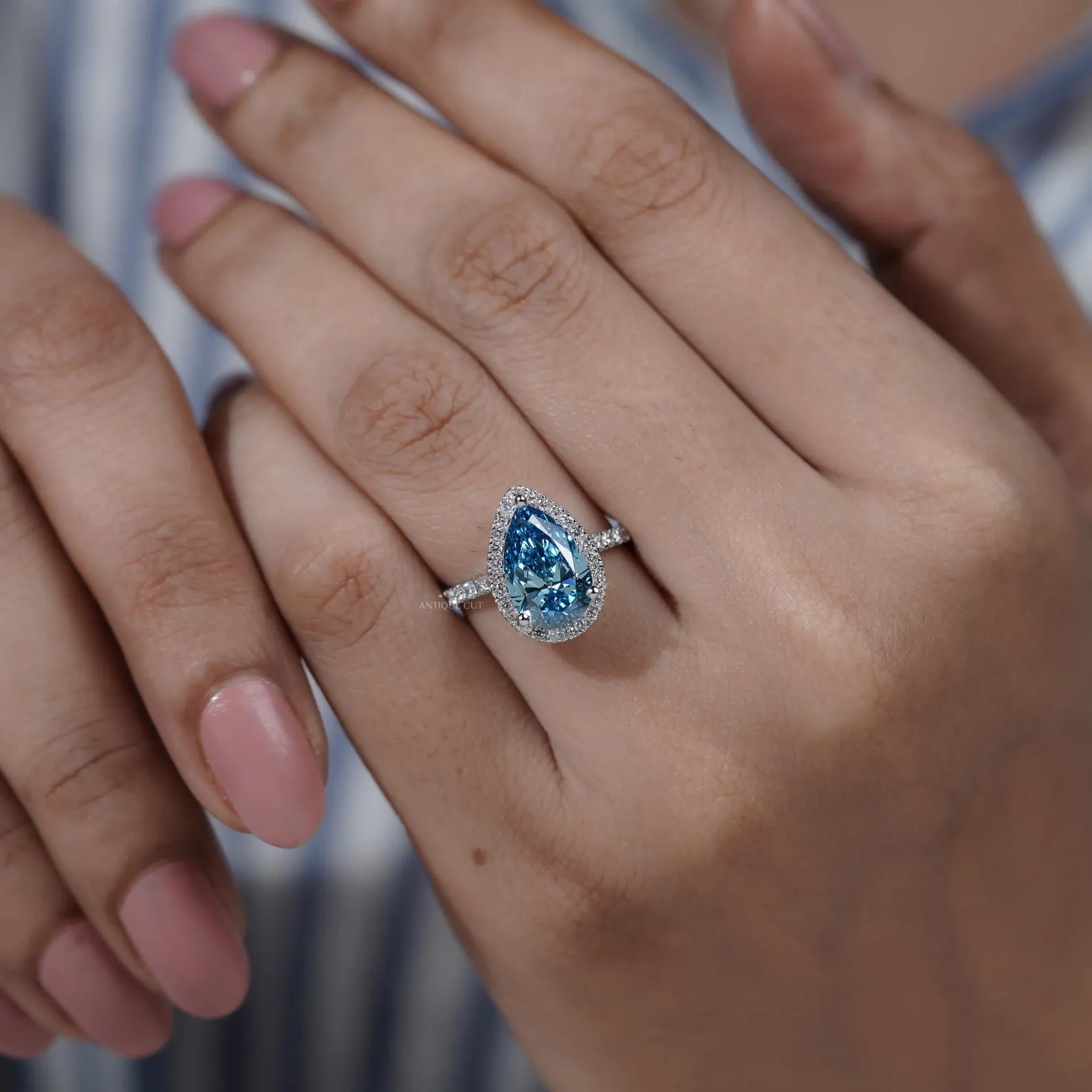 Custom teardrop shaped engagement ring with halo diamonds