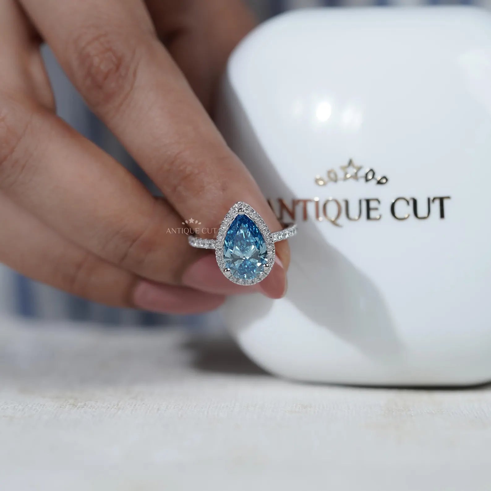 Lab grown teardrop diamond ring with three round prongs