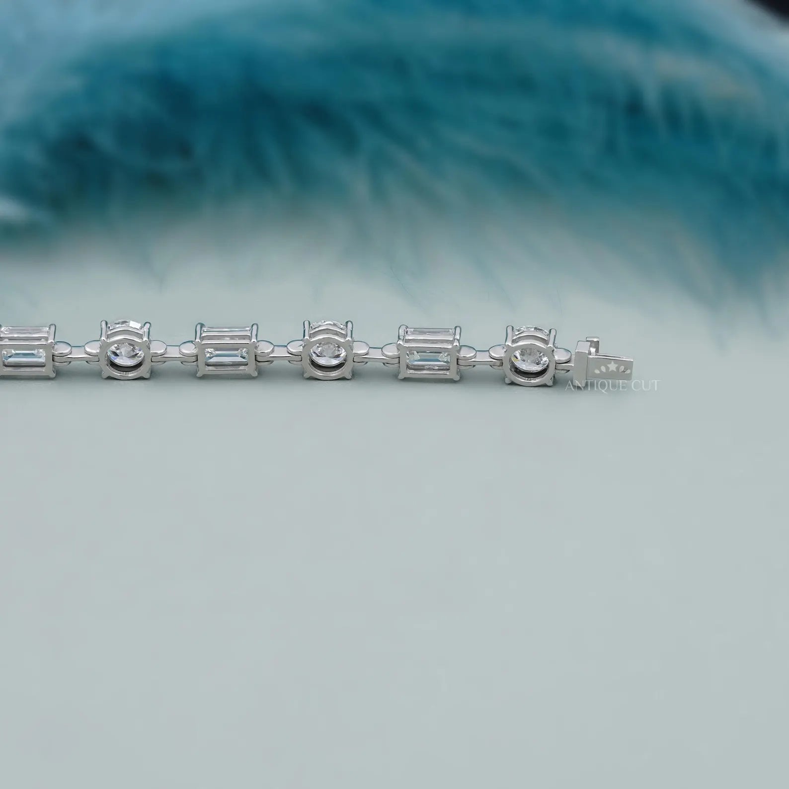 Silver bracelet with diamond accents on a light blue background


