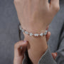 Silver bracelet with diamond accents on a light blue background

