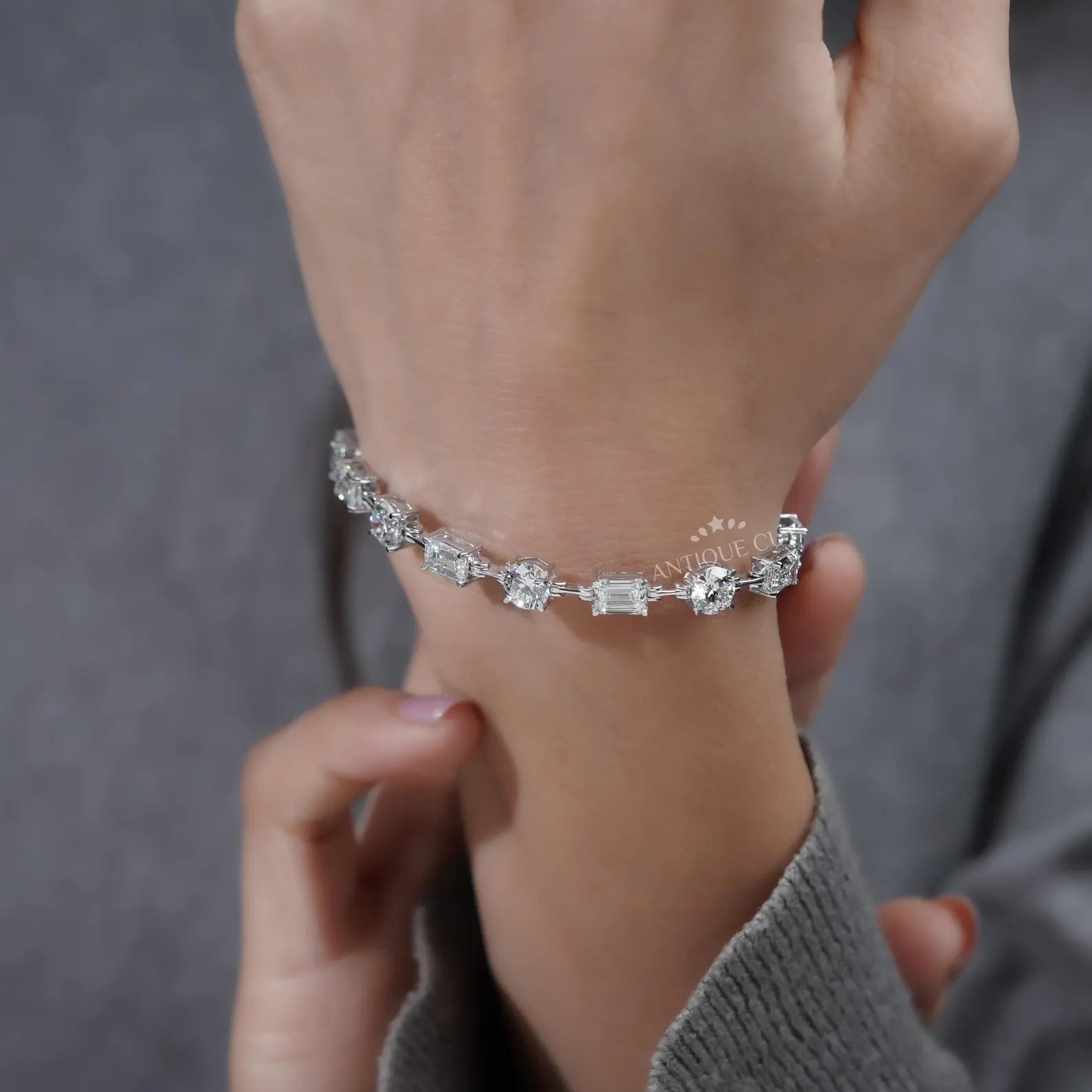 Silver bracelet with diamond accents on a light blue background

