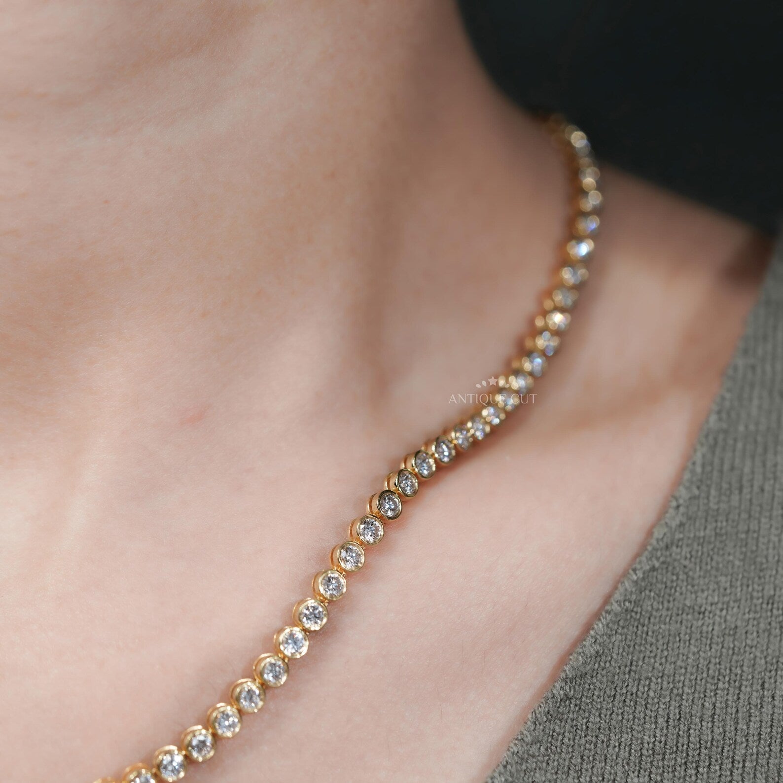 A gold necklace with diamonds on a person's neck
