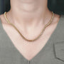 Gold necklace with diamonds on a person's neck