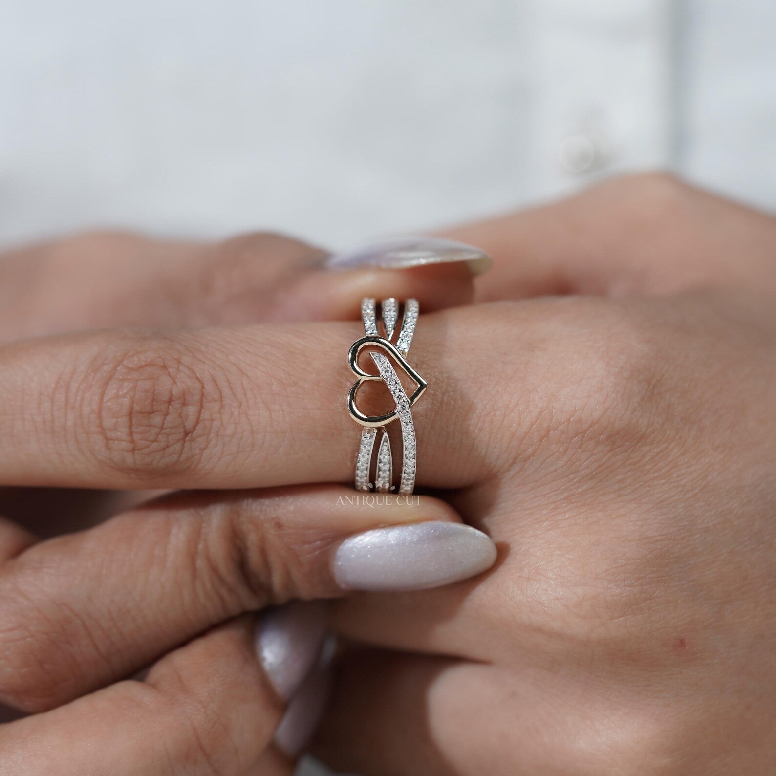 Silver ring with a heart design on hand