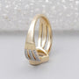 Gold ring with a heart and infinity symbol on a light gray background

