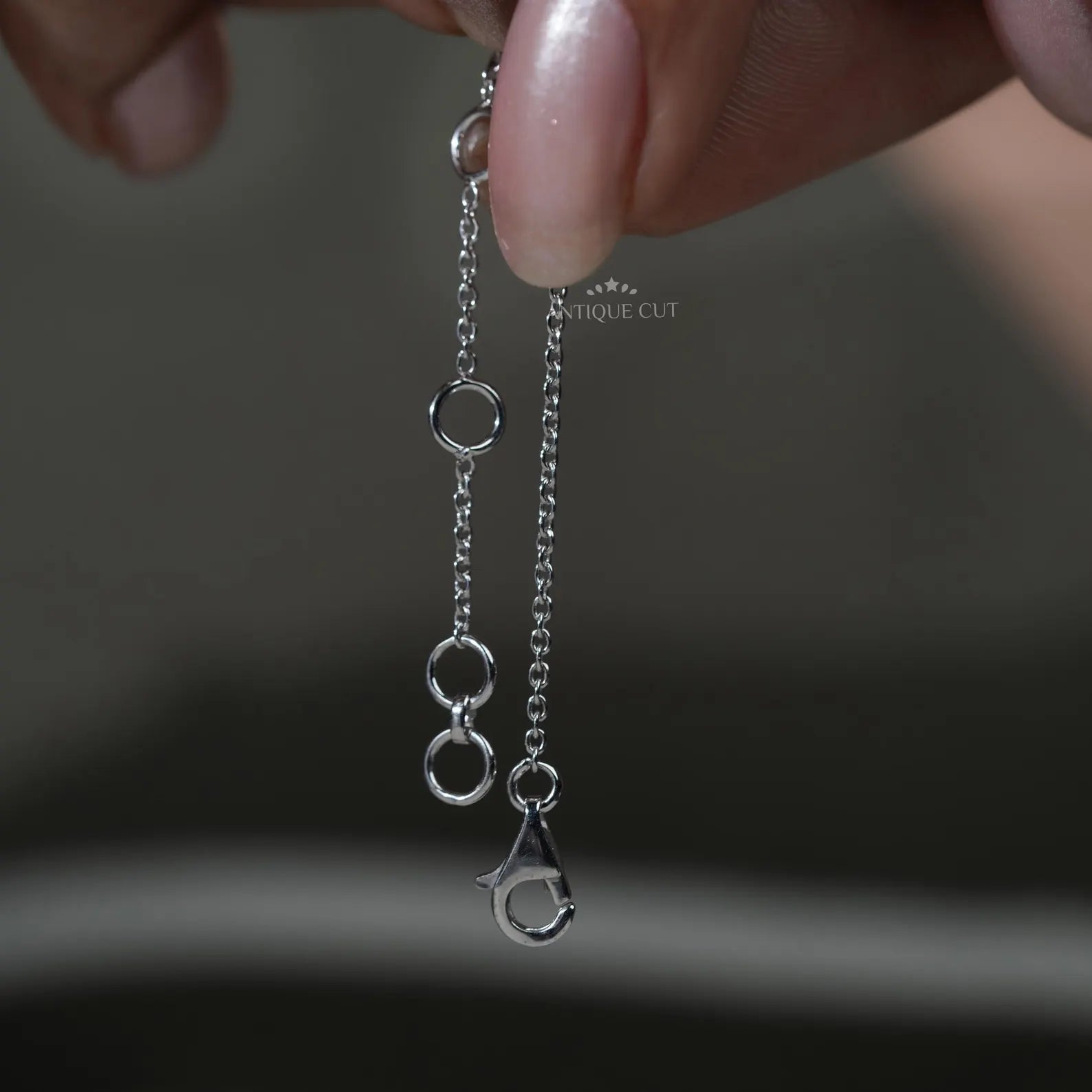 Silver necklace with small diamonds on a person wearing a green top