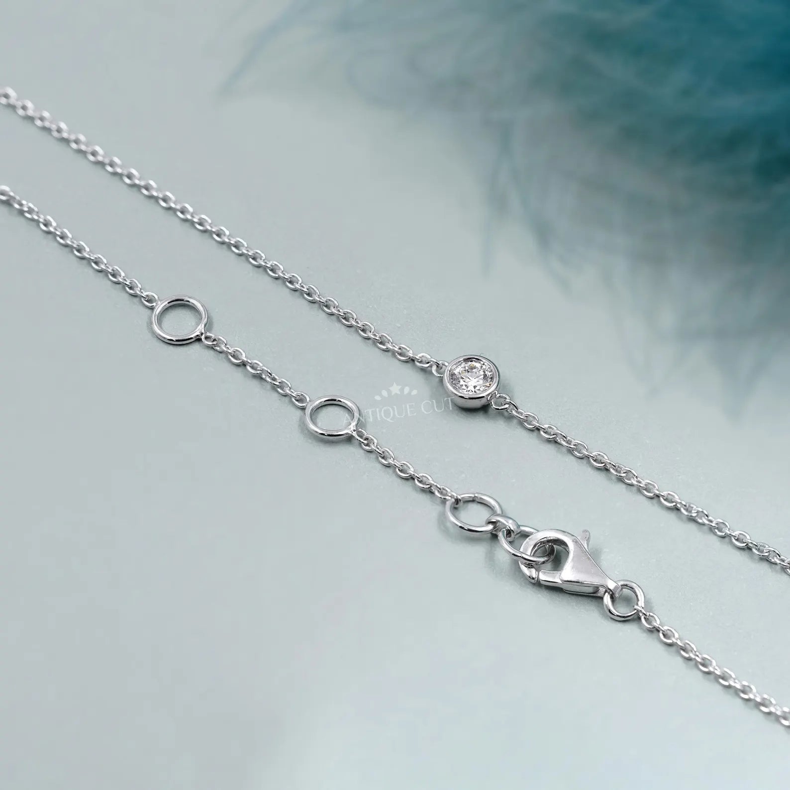 Silver necklace with small diamonds on a person wearing a green top