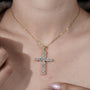 Gold cross necklace with diamonds on a person's neck

