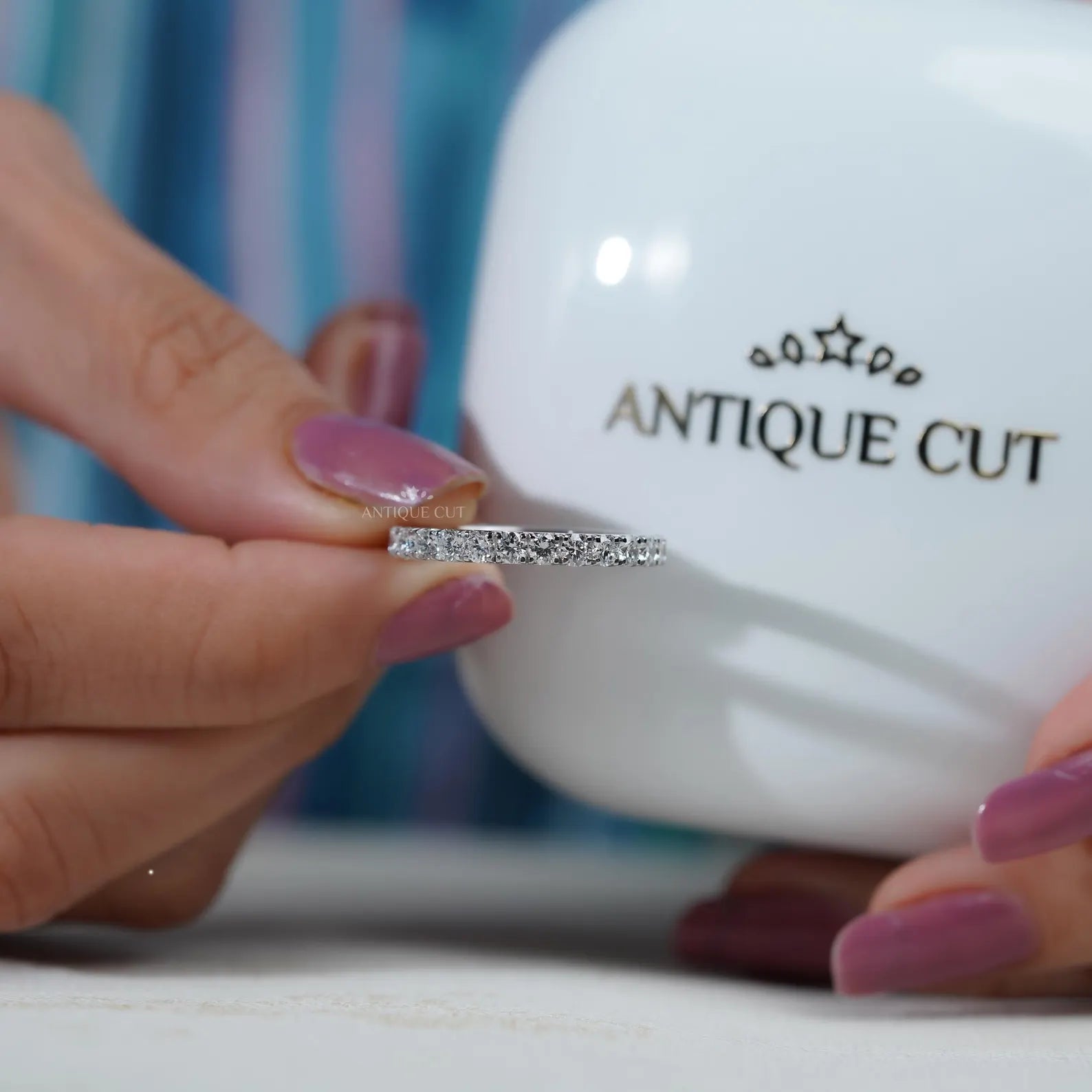 Silver ring with diamonds on a soft blue background

