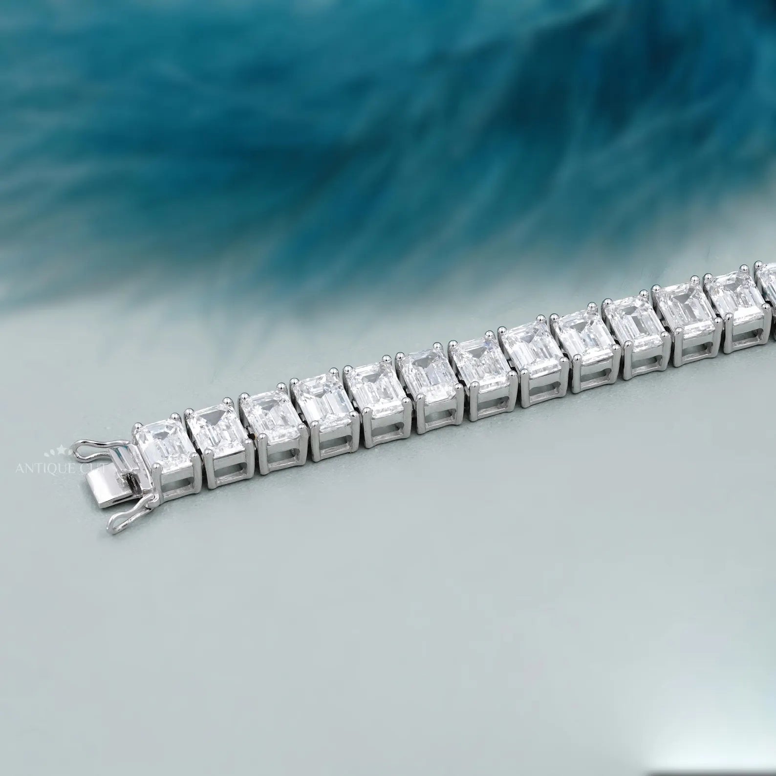 Diamond bracelet with emerald-cut diamonds on a gradient blue and gray background