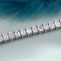 Diamond bracelet with emerald-cut diamonds on a gradient blue and gray background
