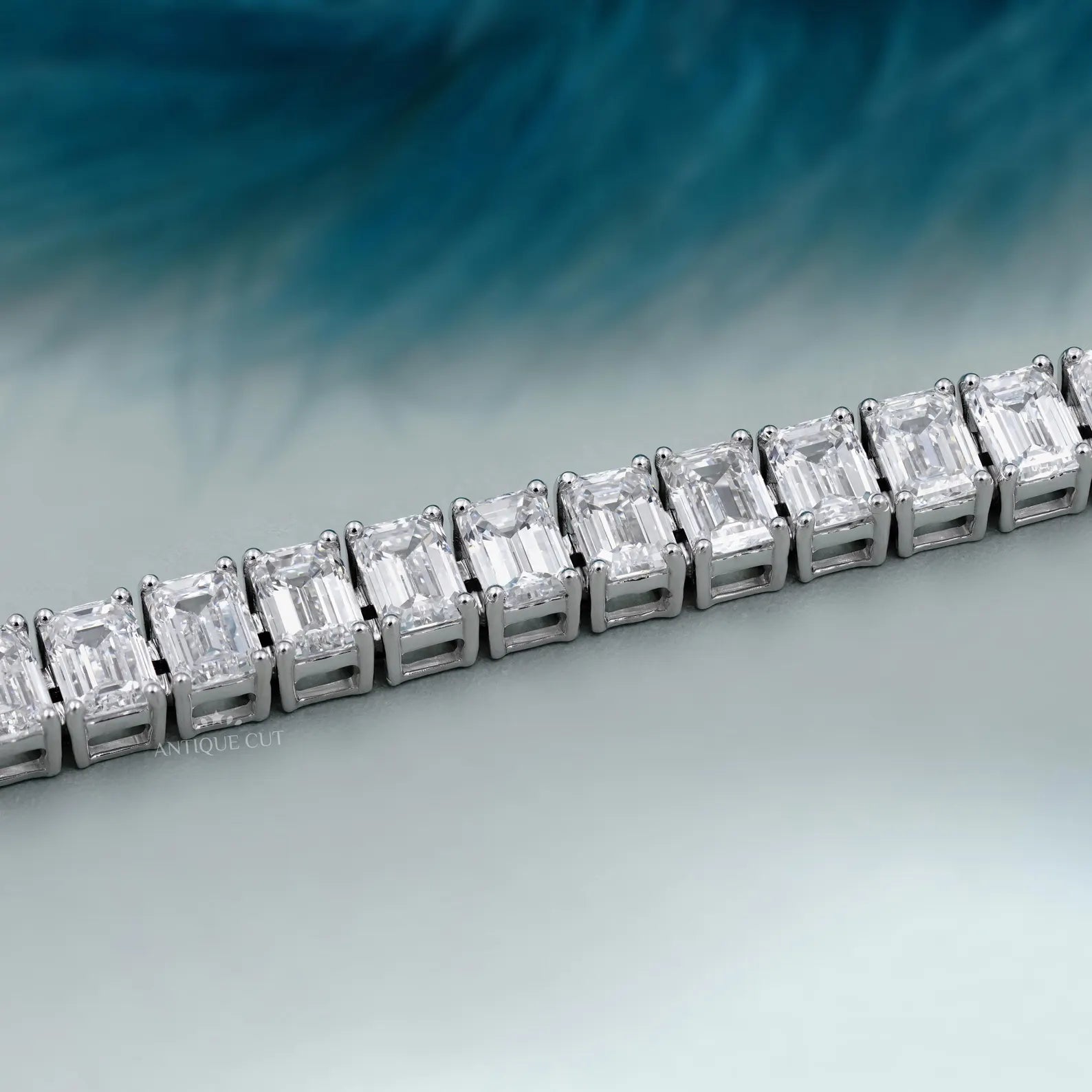 Diamond bracelet with emerald-cut diamonds on a gradient blue and gray background