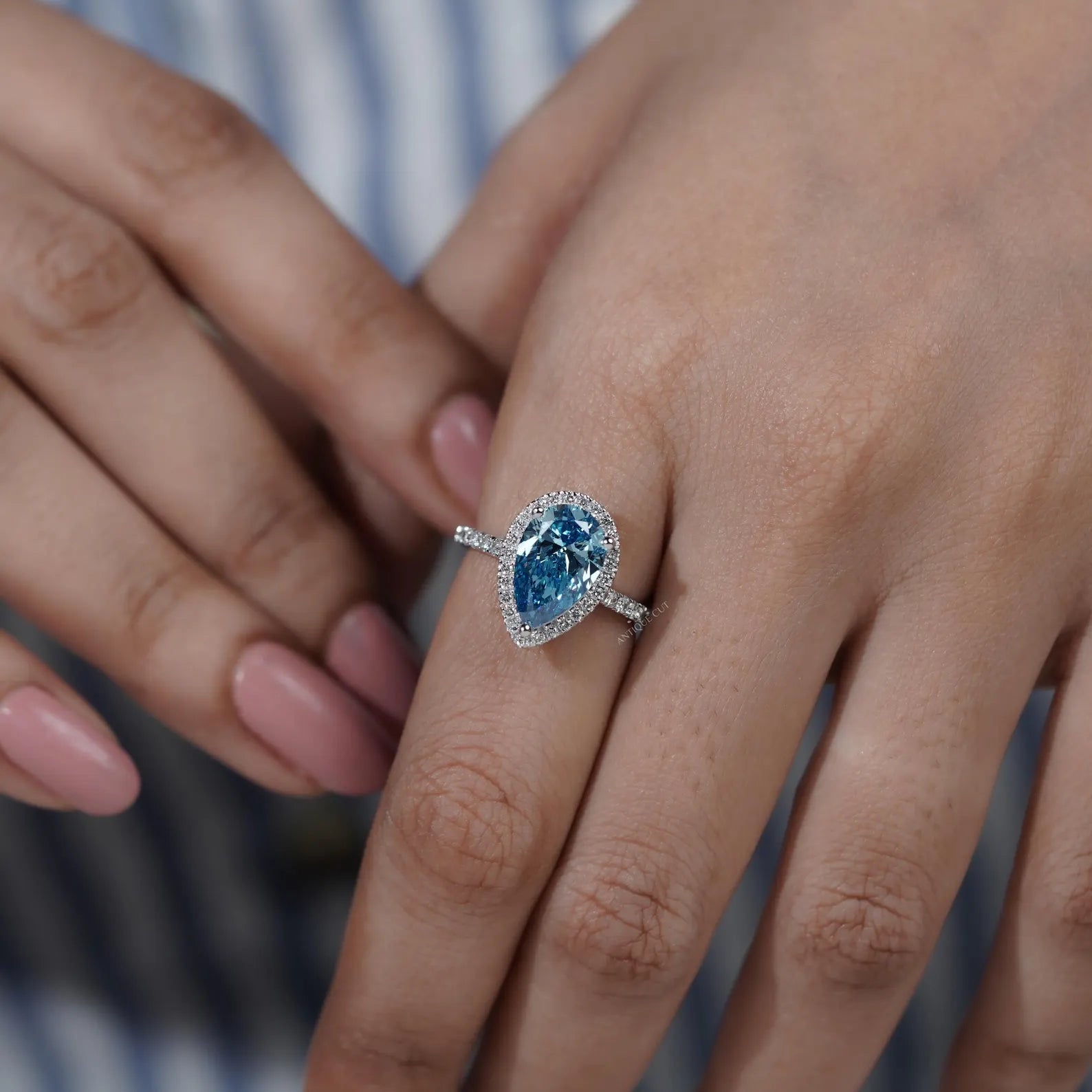 Teardrop shaped engagement ring with round cut pave band