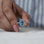 Custom blue diamond engagement ring with halo setting