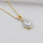 Pear cut pendants in yellow gold with diamond halo