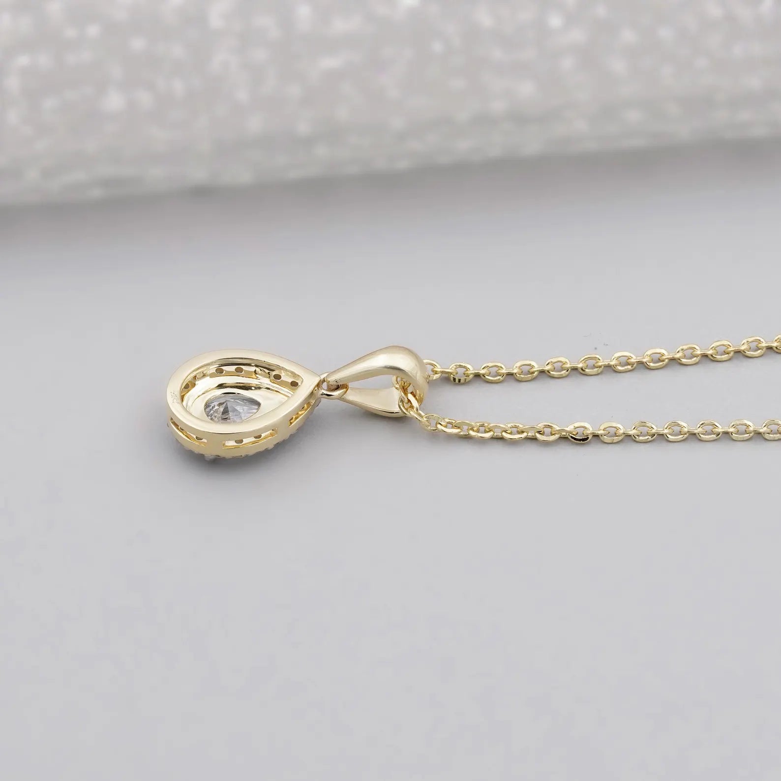 Round cut halo setting around pear cut center stone