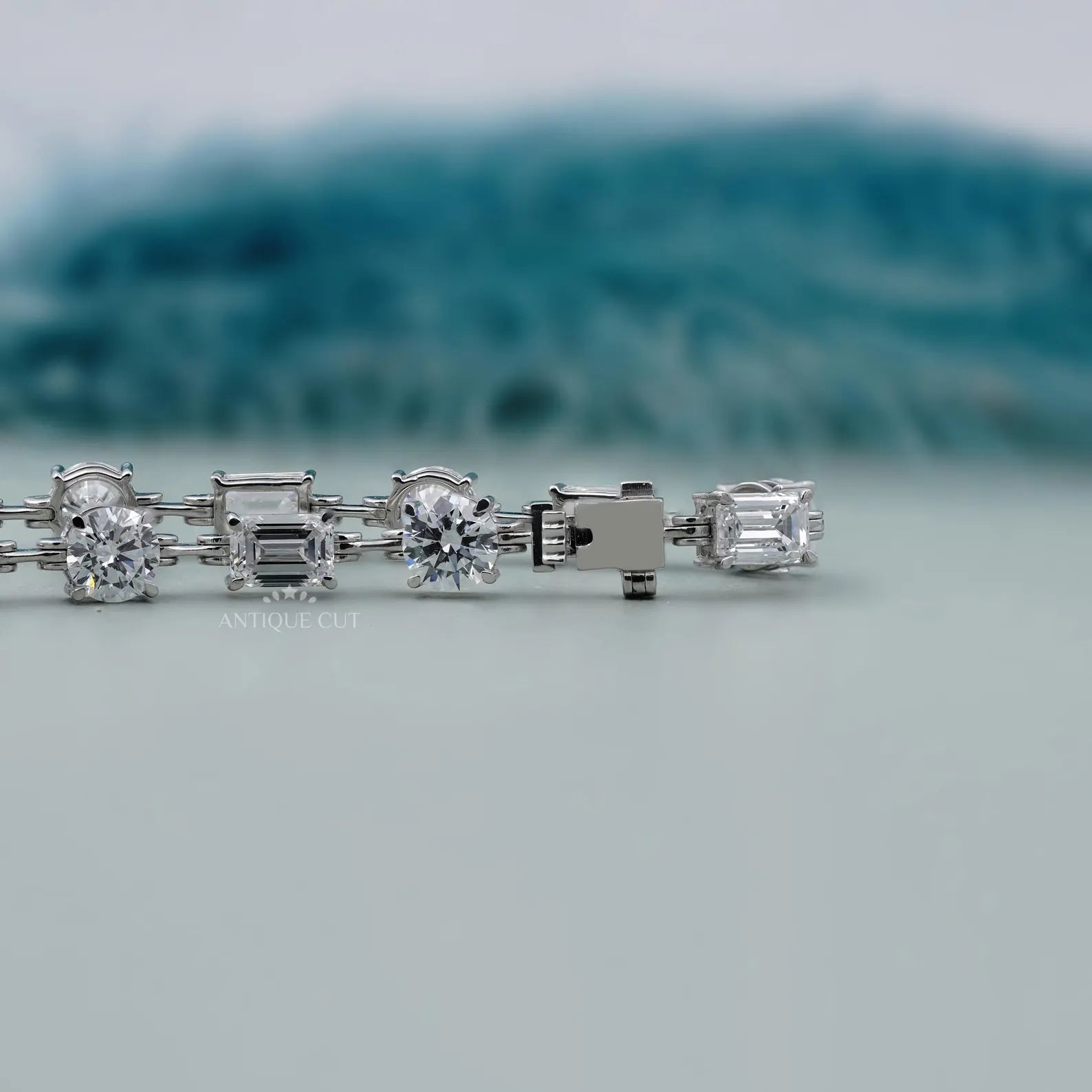 Diamond bracelet with various cut stones on a light gray background