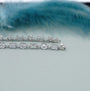 Silver bracelet with diamond accents on a light blue background

