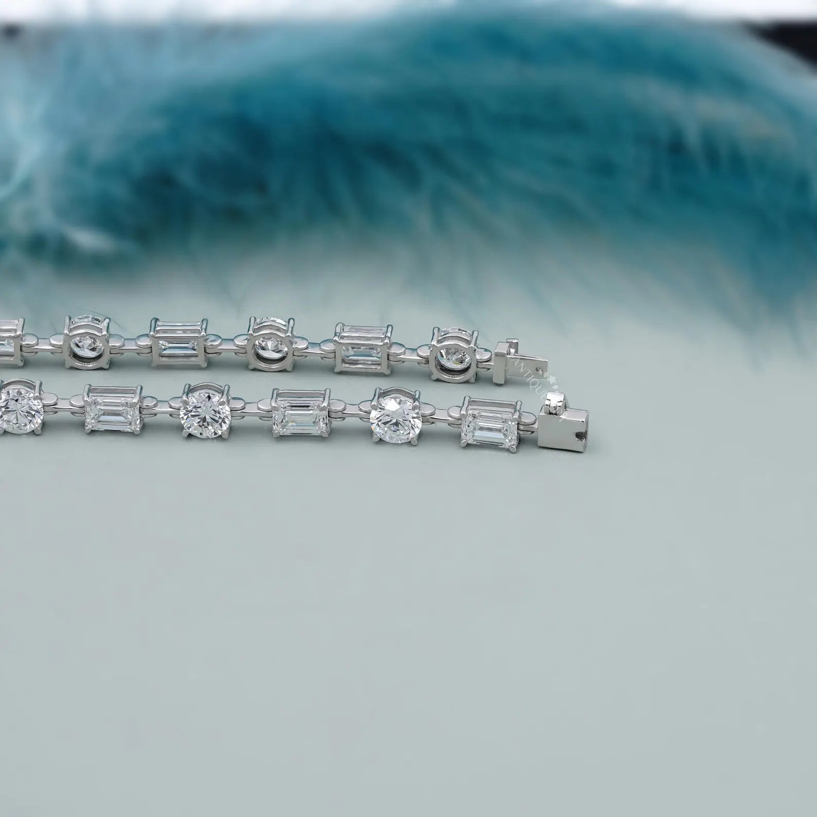 Silver bracelet with diamond accents on a light blue background

