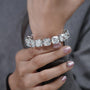 Silver bracelet with large gemstones on a light blue background