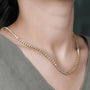 Gold necklace with diamonds on a person's neck