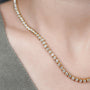 Gold necklace with diamonds on a person's neck