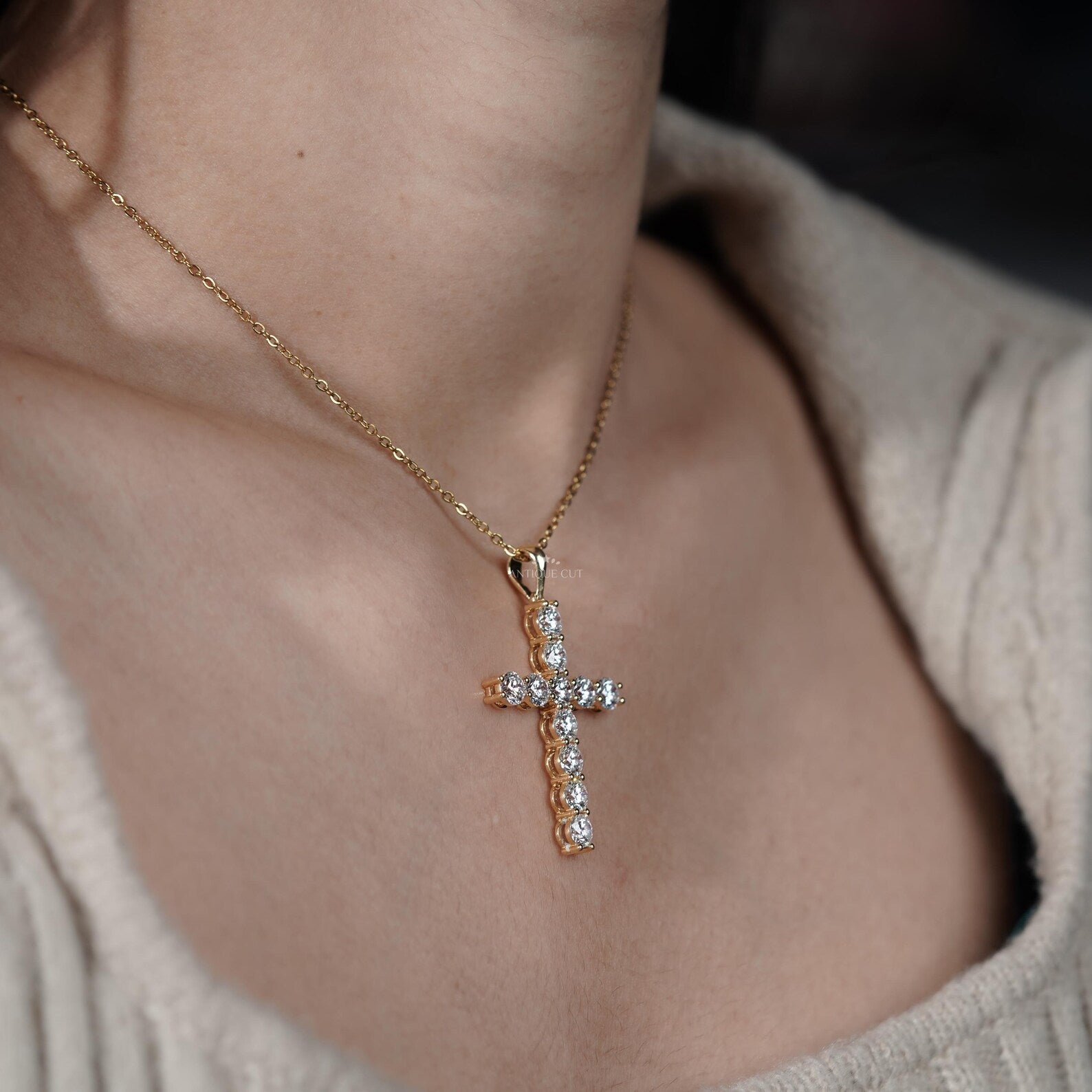 Gold cross necklace with diamonds on a person's neck

