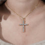 Gold cross necklace with diamonds on a person's neck

