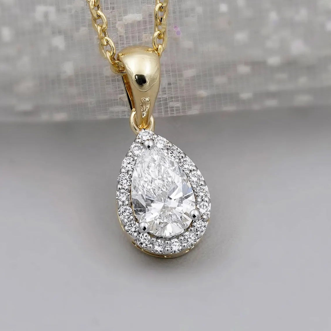 Yellow gold halo diamond pendant with pear cut center stone