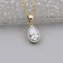 Yellow gold halo diamond pendant with pear cut center stone