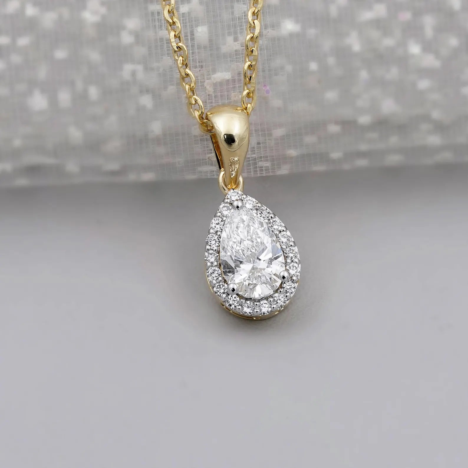 Yellow gold halo diamond pendant with pear cut center stone