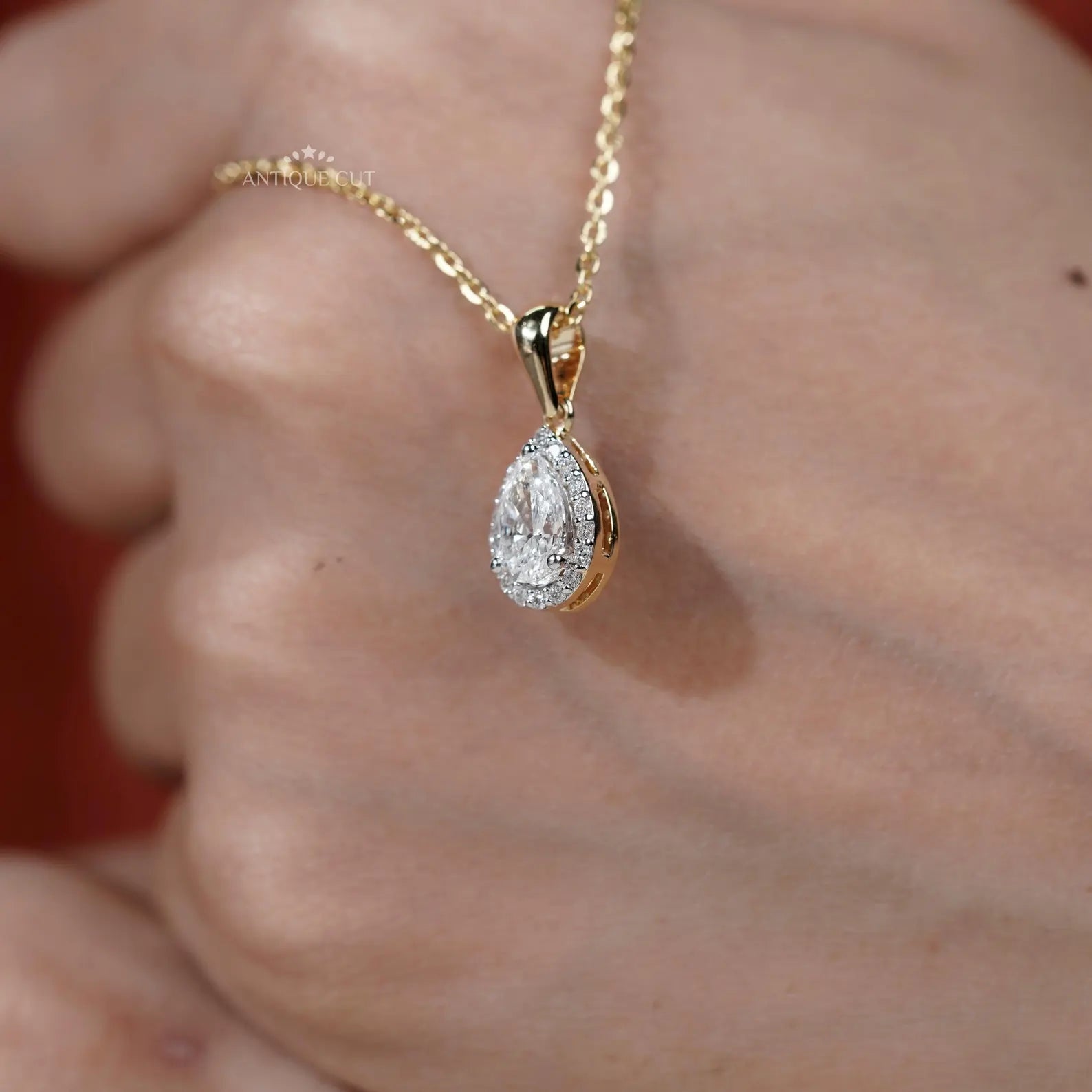 Pear shaped halo diamond pendant in yellow gold