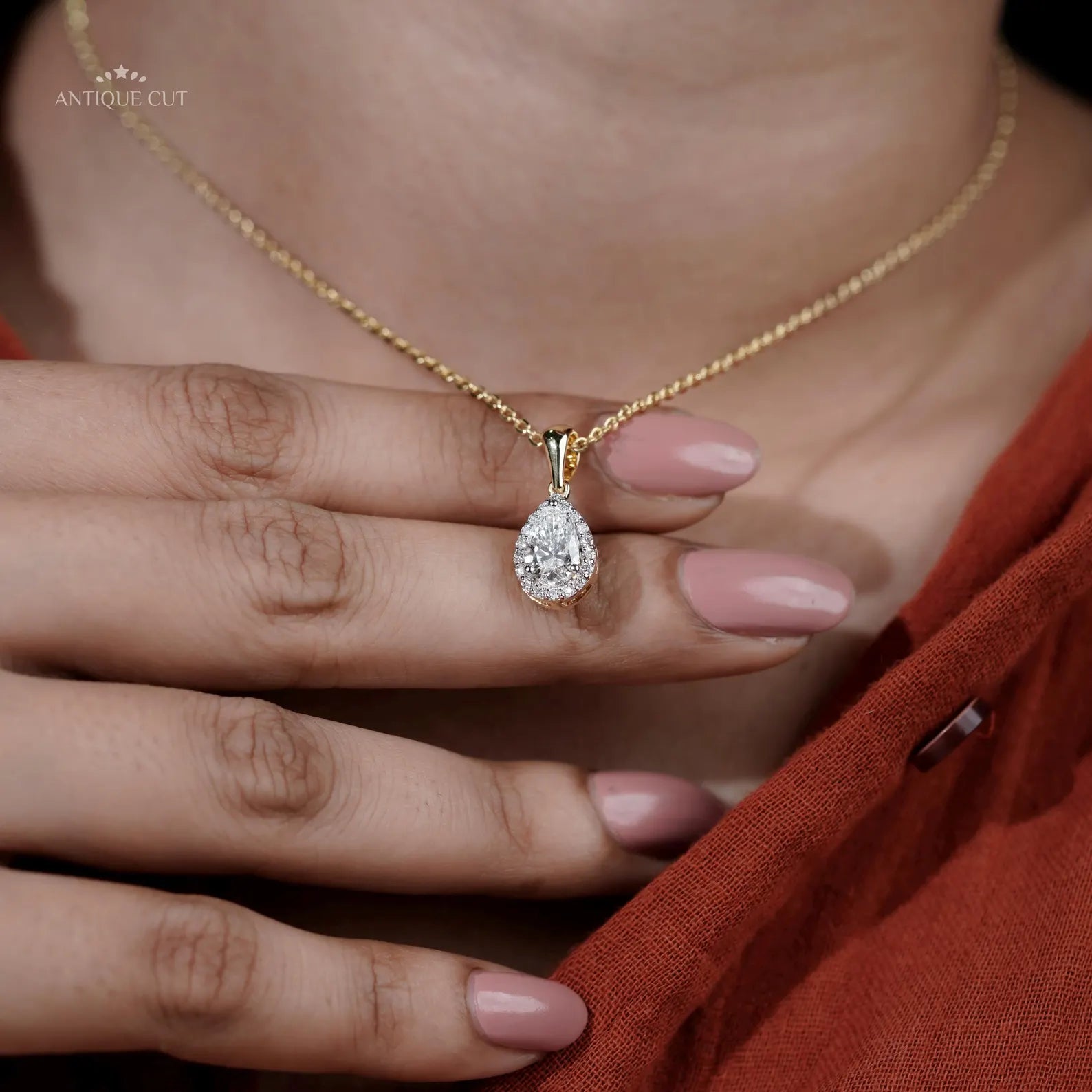 Yellow gold pendant bail holding pear cut diamond