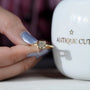 R letter engagement ring with bezel set diamond in yellow gold