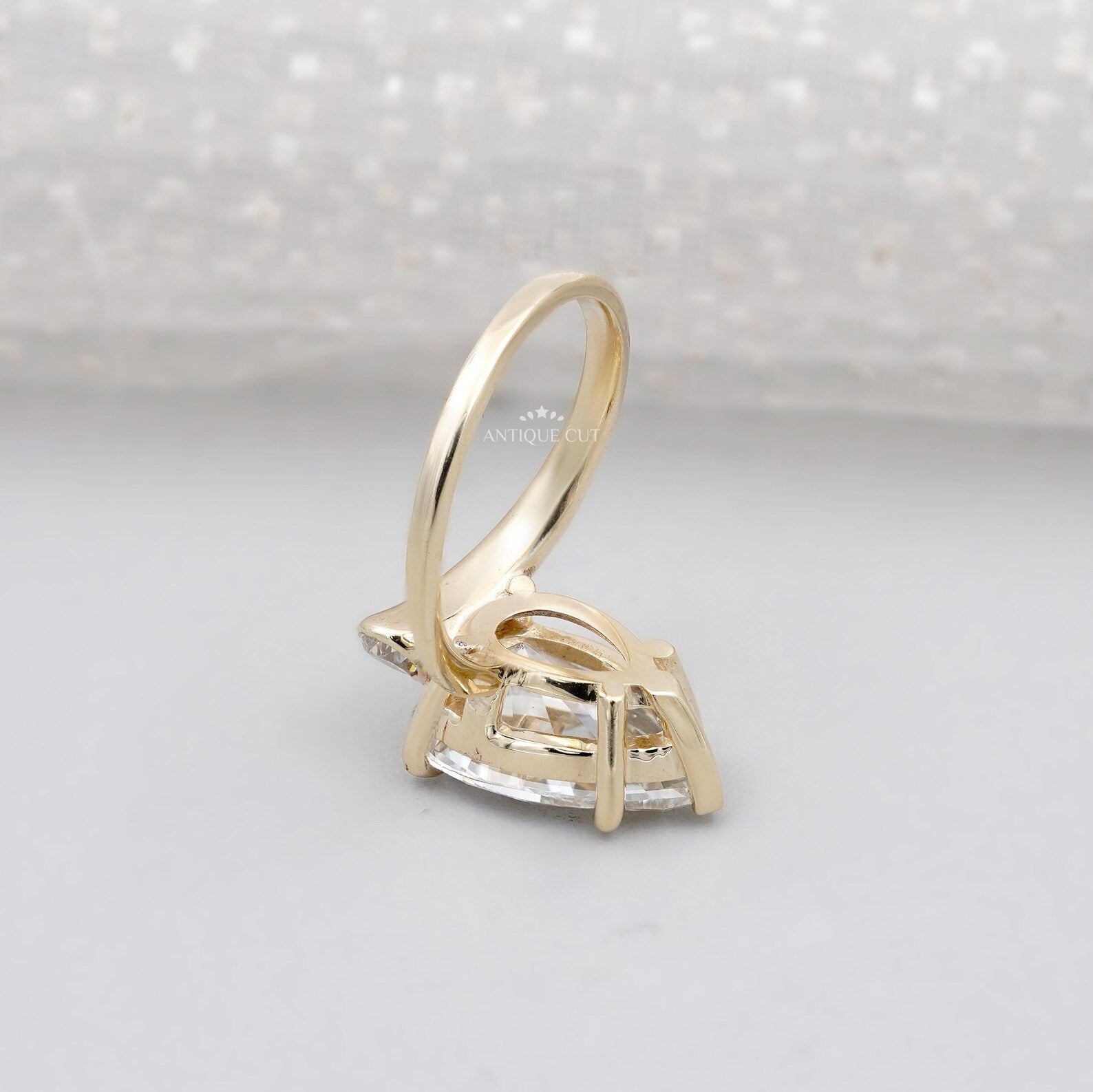 Pear shaped diamond engagement ring with side stones and claw prong setting
