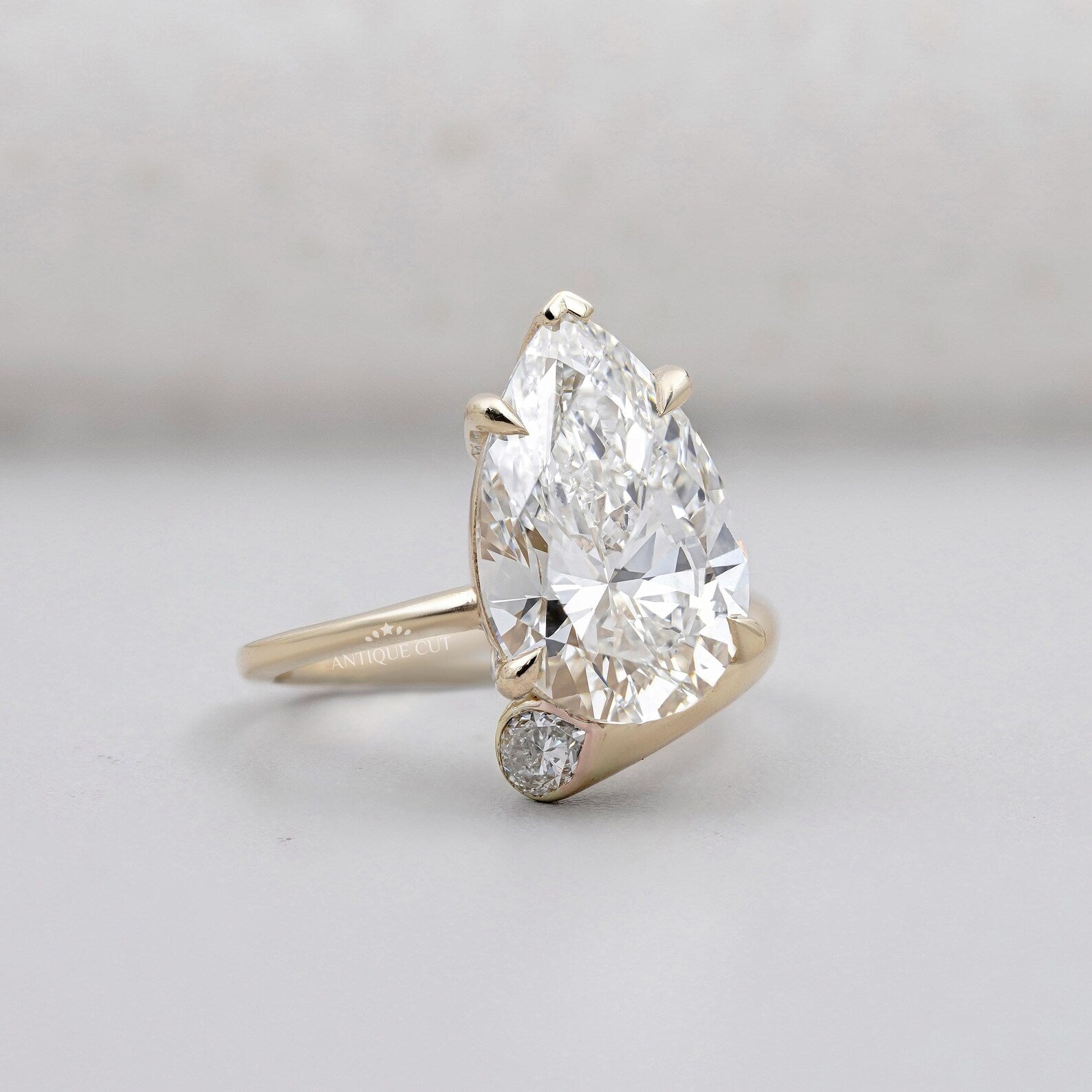 IGI certified pear shaped diamond ring with side stone design by Antiquecut