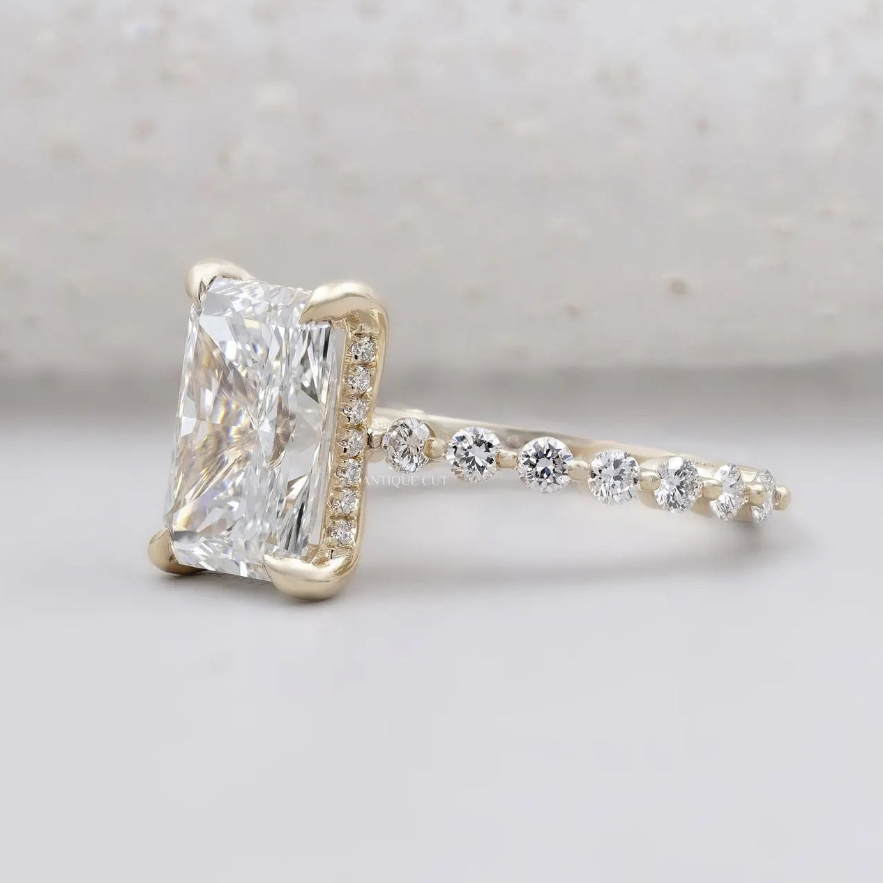 Lab grown radiant diamond ring with pavé band and yellow gold claw prong setting