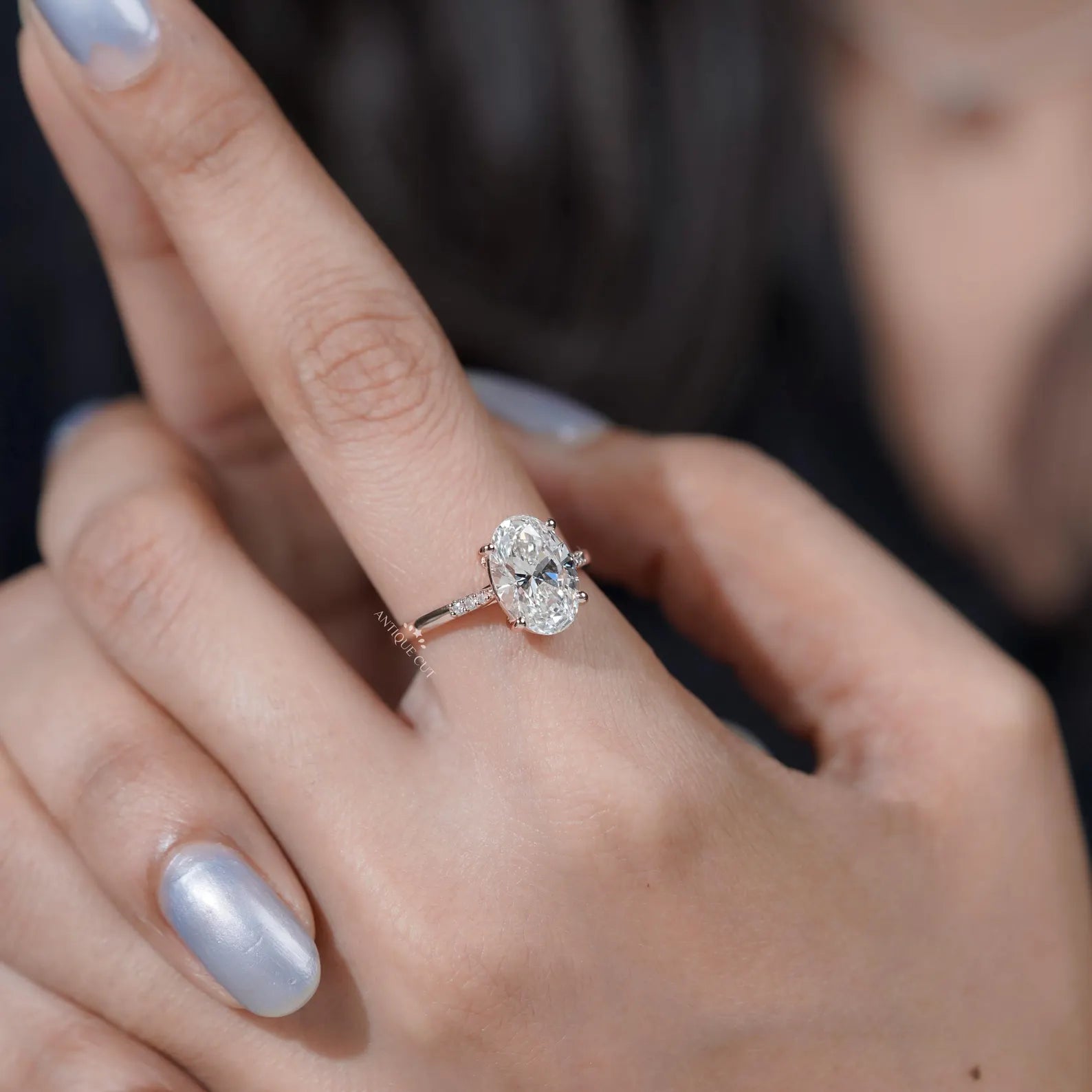 Oval diamond cathedral engagement ring with pavé band