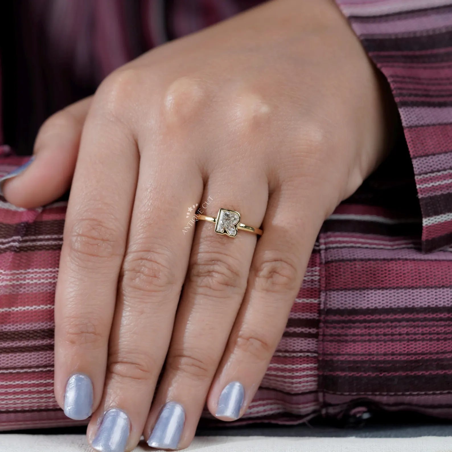 R letter yellow gold ring featuring a bezel set diamond