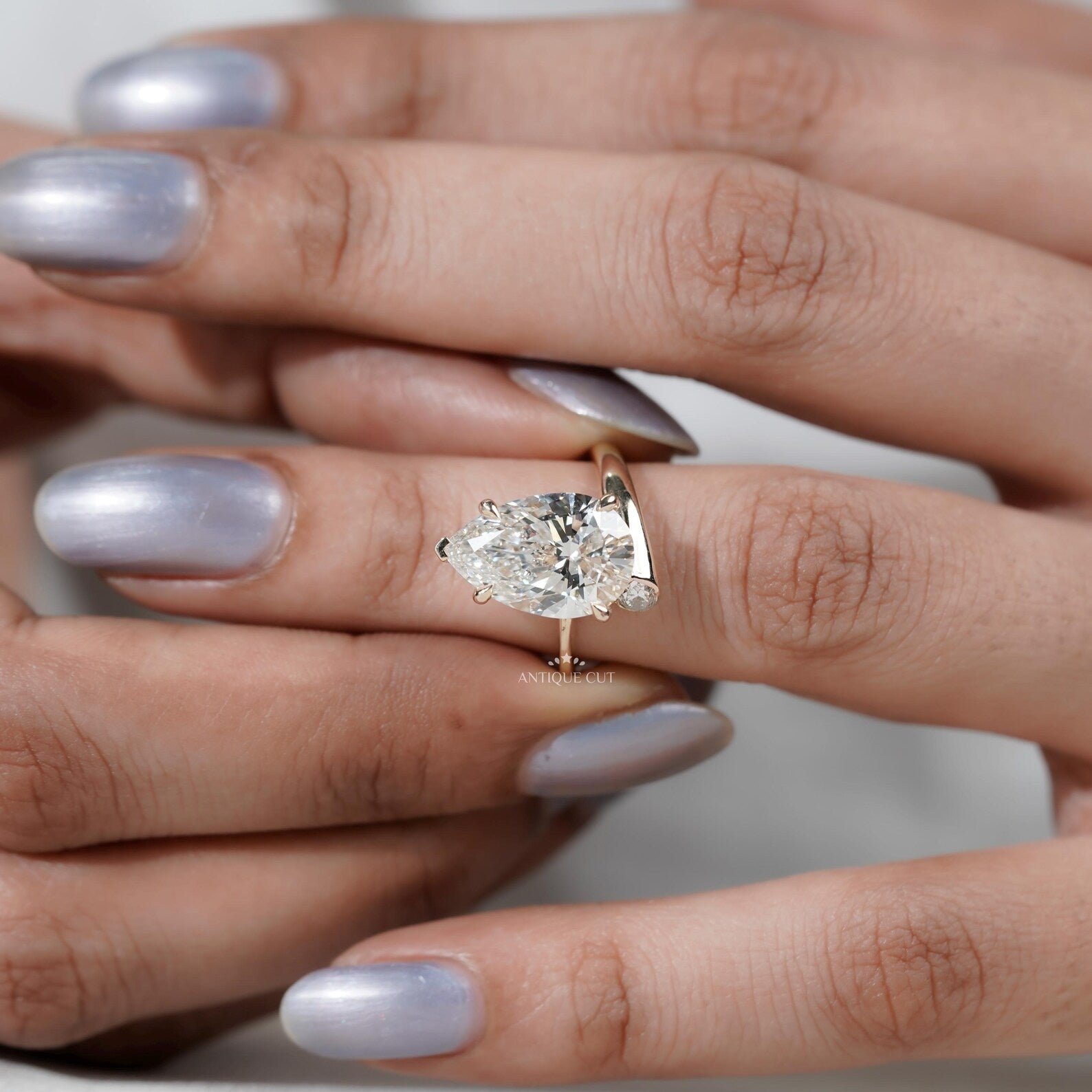 Pear shaped diamond ring with protective V prong and claw prong setting