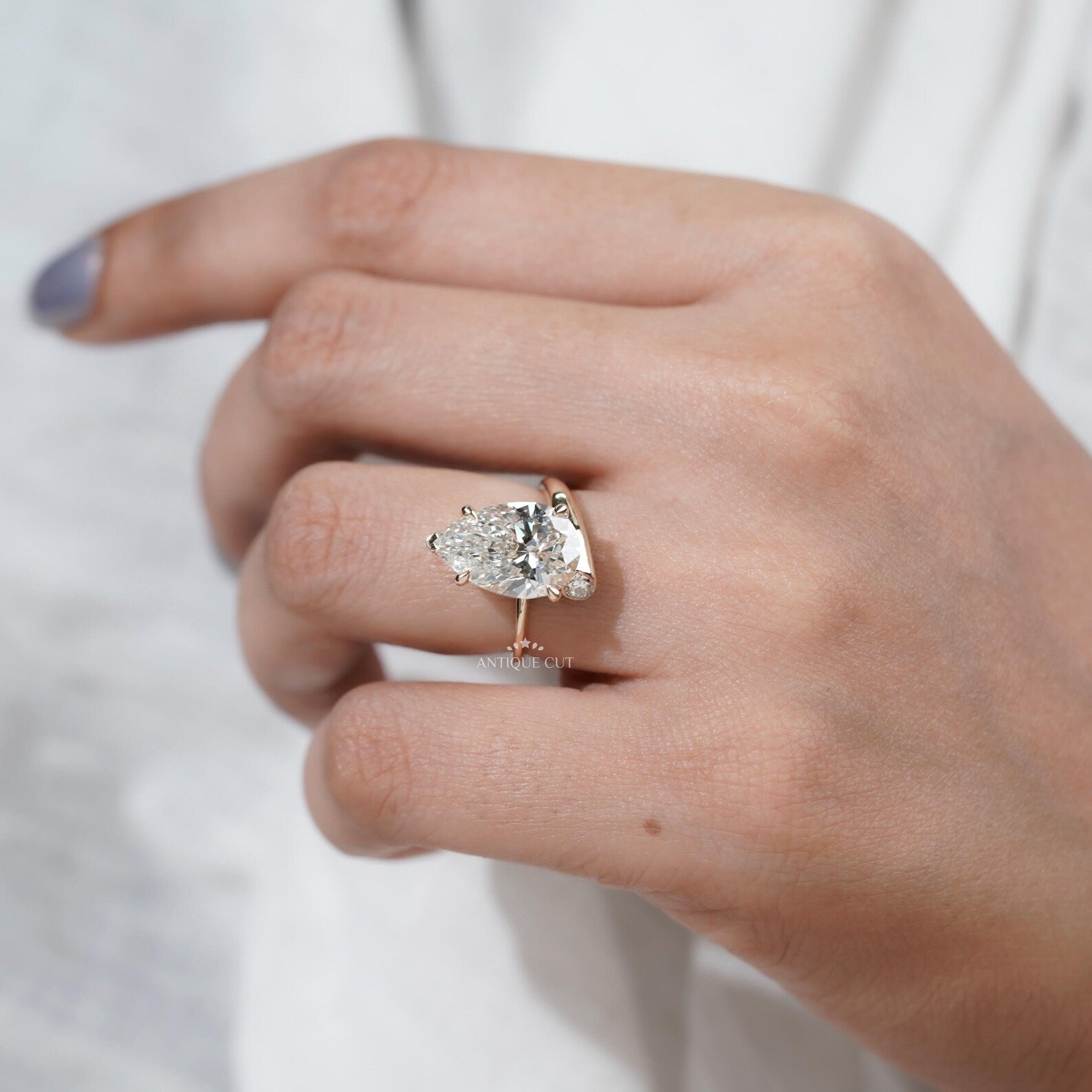 Lab grown pear shaped engagement ring with side diamonds in yellow gold